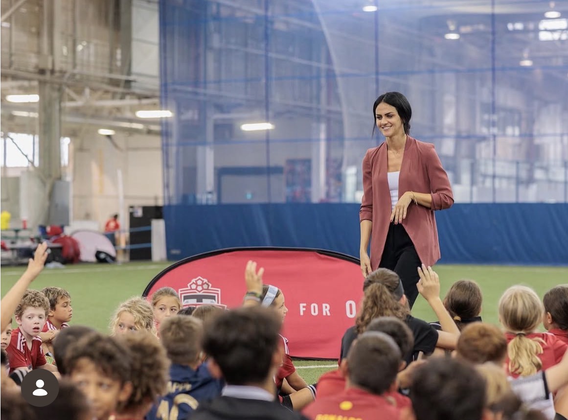 Tania with a group of children on a soccer field